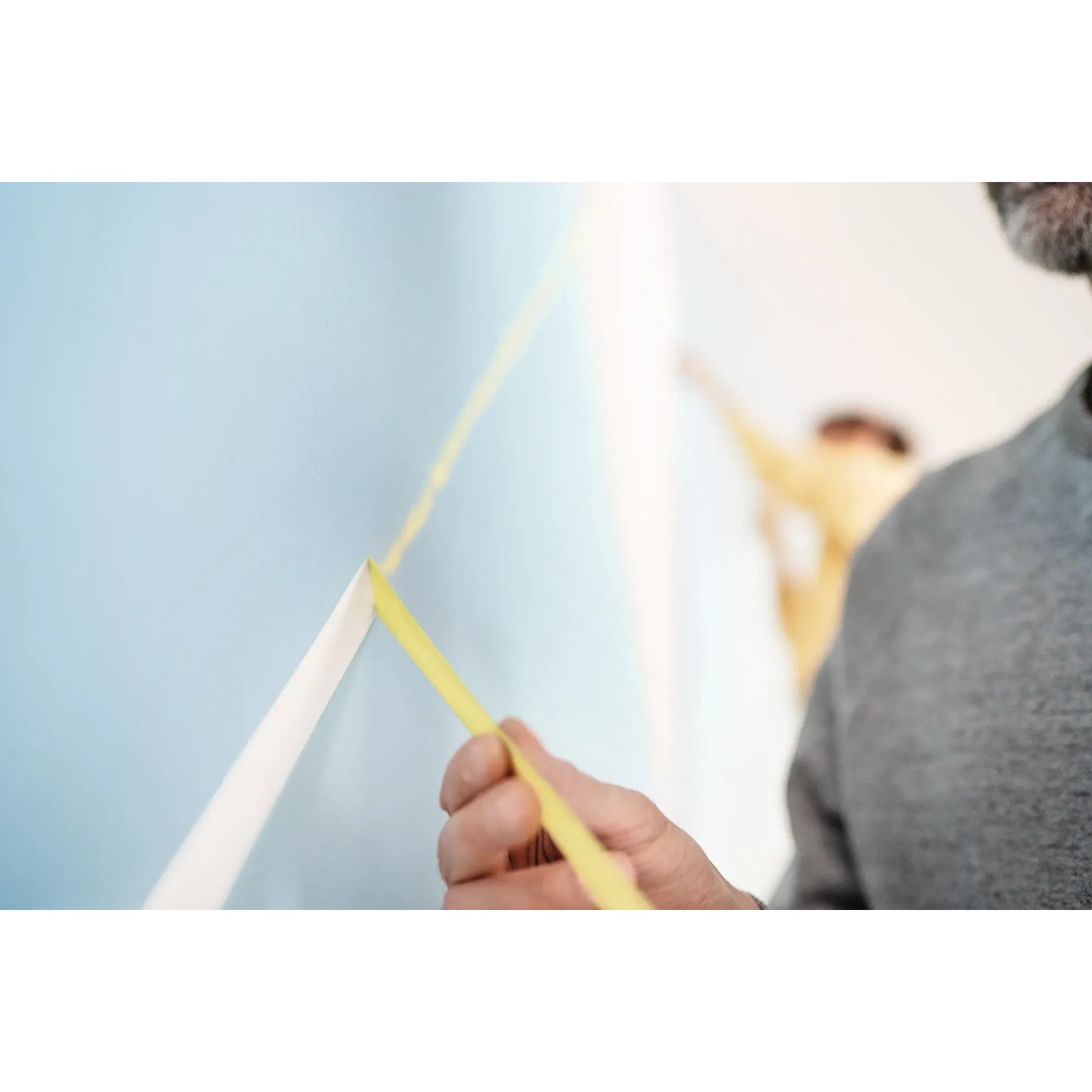 Anwendung von Tesa Malerband Professional (25mm) zum Abkleben einer Wand für präzise Farbkanten.