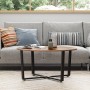 Runder holz4home Couchtisch Indie im Industrie-Stil mit schwarzem Metallgestell vor grauem Sofa.