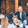 Mann lädt Brennholz in schwarzen Relaxdays Handwagen im Schnee. Robuster Transportwagen für Camping & Garten.
