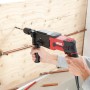 Skil Bohrhammer 1770GA in Nutzung: Roter Bohr- und Meißelhammer bohrt in eine Holzwand.
