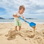 Kind schaufelt Sand mit blauer Hape Sandschaufel am Strand. Sandspielzeug für Spiel & Spaß.