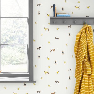 Vliestapete Harbour Dogs Crème: Wand mit Hunde-Motiven in Gelb und Blau auf Creme.