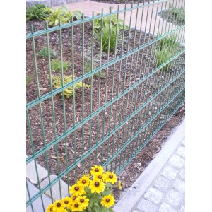 Grünes Doppelstabmattenzaun-Set (5 Stk.) im Garten mit Blumen. Stabiler Gartenzaun für vielseitige Anwendungen.