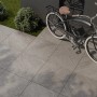 Cersanit Bolt Terrassenplatten aus Feinsteinzeug, 59,3x59,3 cm, in Grau verlegt mit Fahrrad.