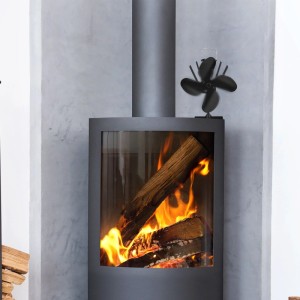 Schwarzer, wärmebetriebener Ofenventilator auf modernem Kamin mit brennendem Holz. Optimale Wärmeverteilung.