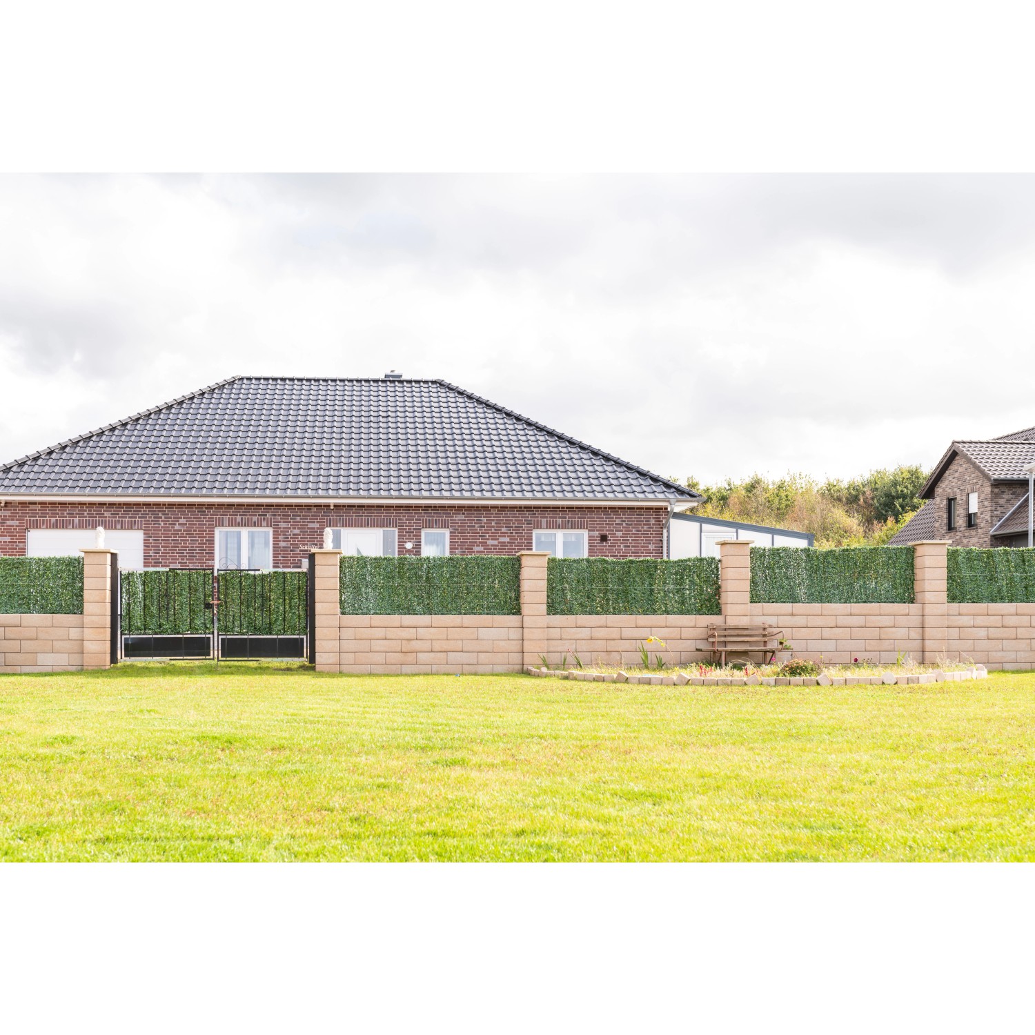 Diephaus Mauer Canta Normalstein Sandstein als Garteneinfassung mit Tor und Bewuchs.