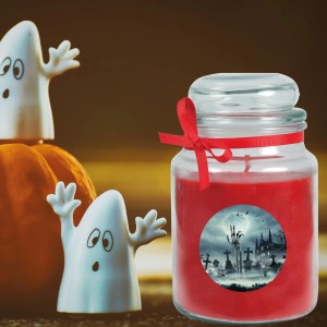 Rote Halloween Duftkerze im Glas mit Friedhof-Motiv und Schleife, neben Kürbis und Geistern.