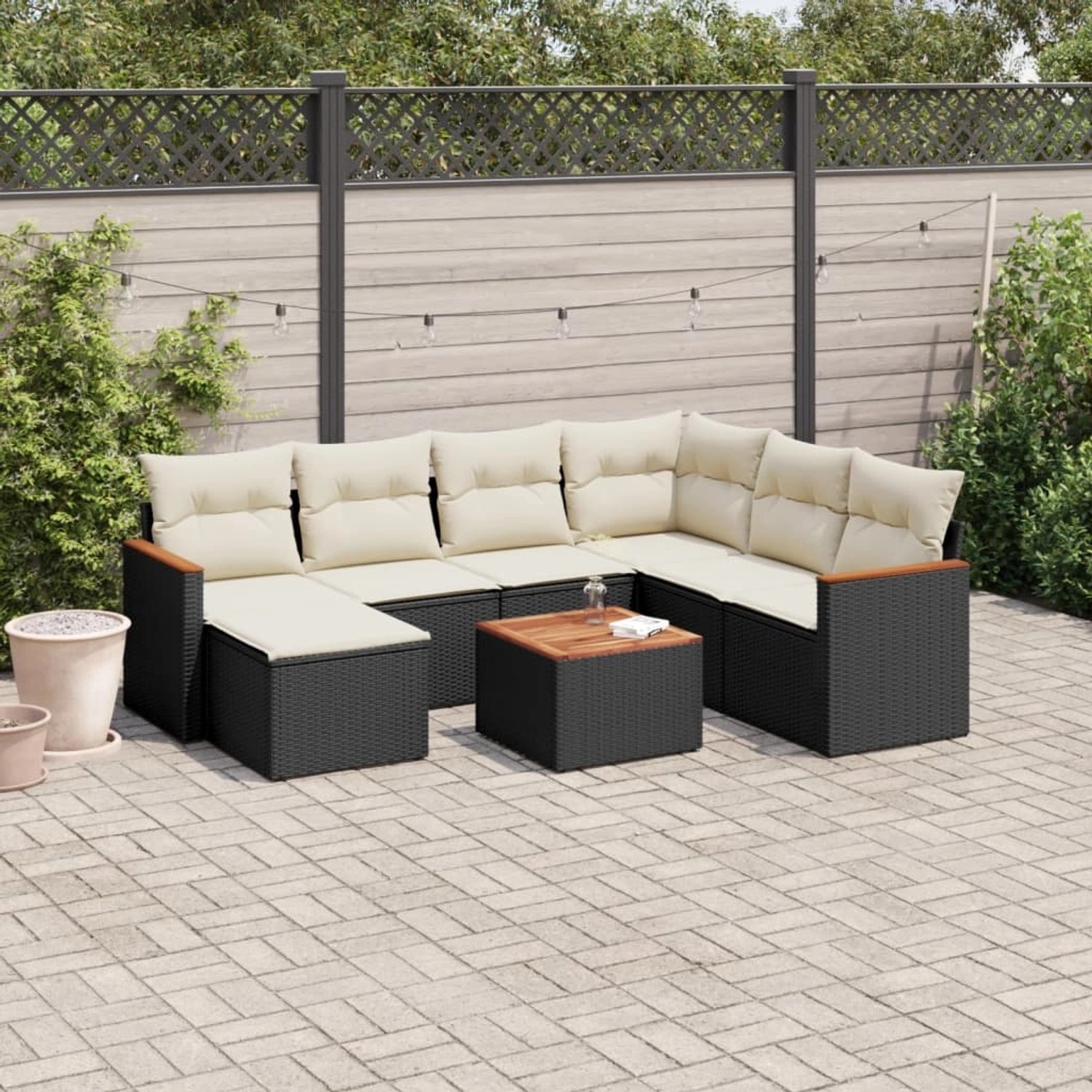 Schwarze 8-tlg. Garten-Sofagarnitur aus Rattan mit cremefarbenen Kissen und Akazientisch.