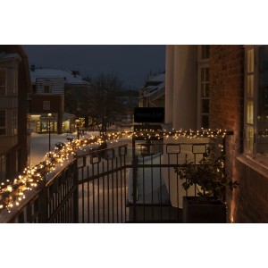 Konstsmide Micro-LED Lichterkette mit 400 warmweißen Dioden auf einem Balkon im Winter.