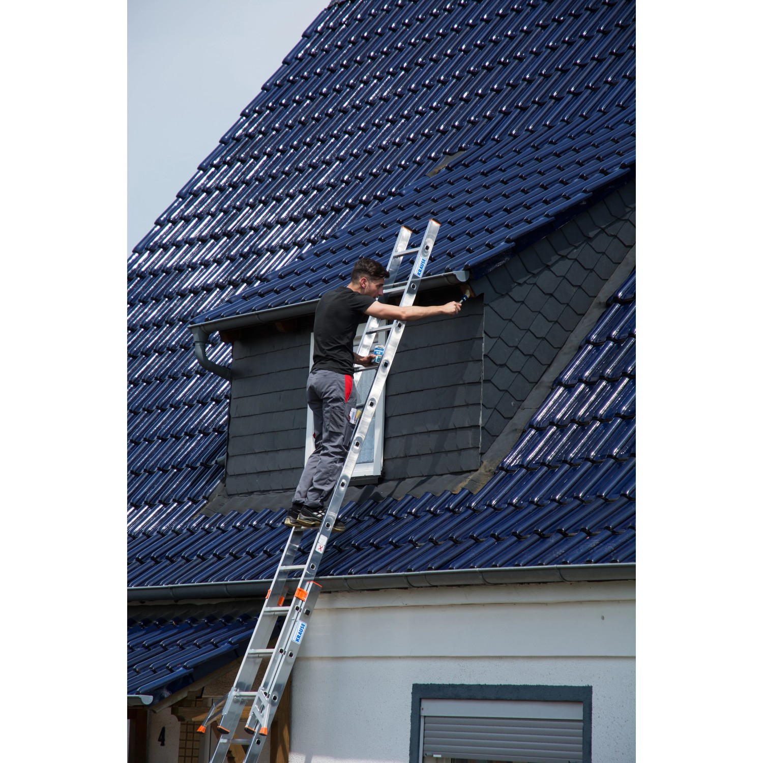 Krause Fabilo Schiebeleiter mit Mann bei Fassadenarbeiten an einem Haus.