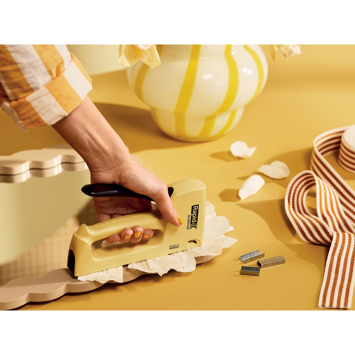 Rapid Handtacker R53 Blomster in Gelb beim Tackern von Papier auf Holzleiste.