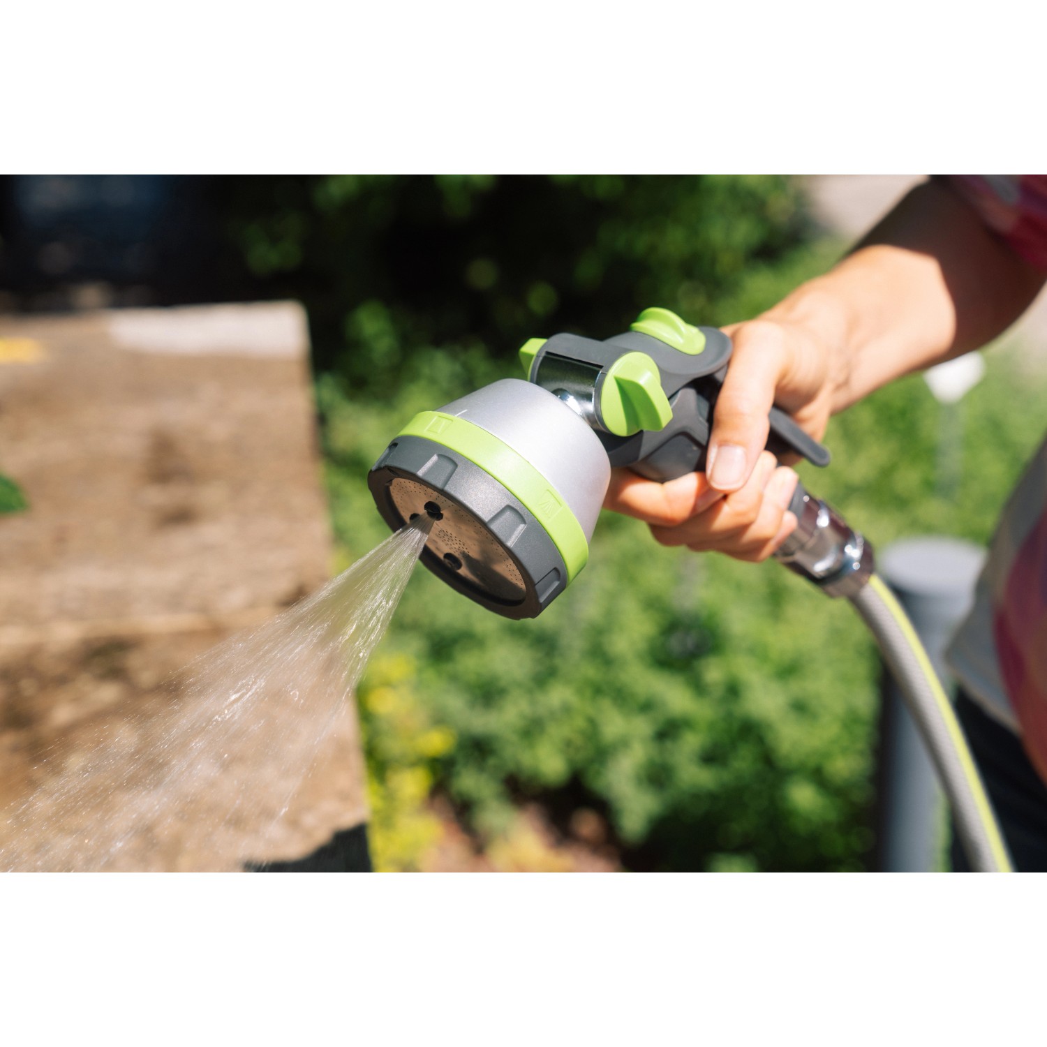 Geka Multibrause Plus 5S Grau in Aktion: Hand hält Gartenspritze mit Wasserstrahl.