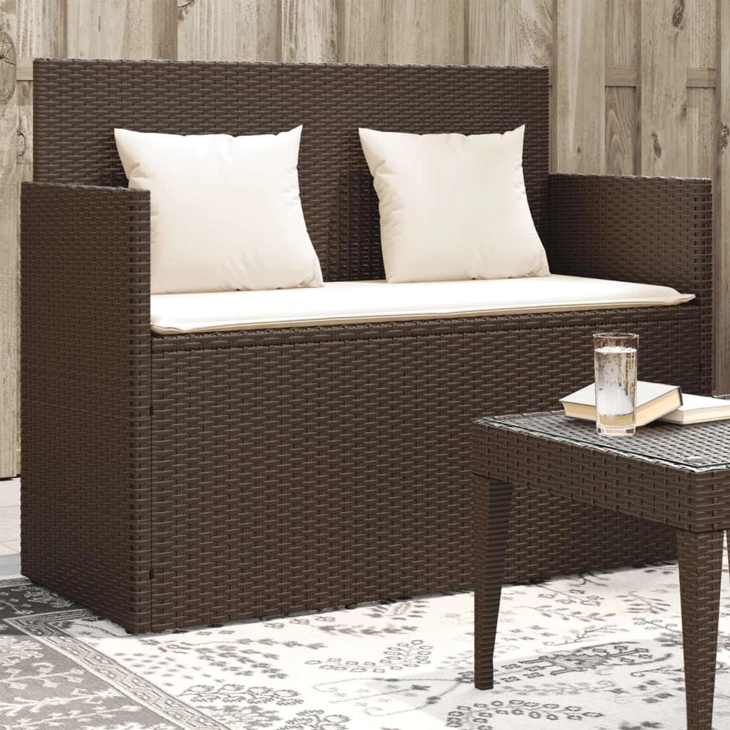 Braune furnicato Gartenbank aus Rattan mit cremefarbenen Kissen und Stauraum.
