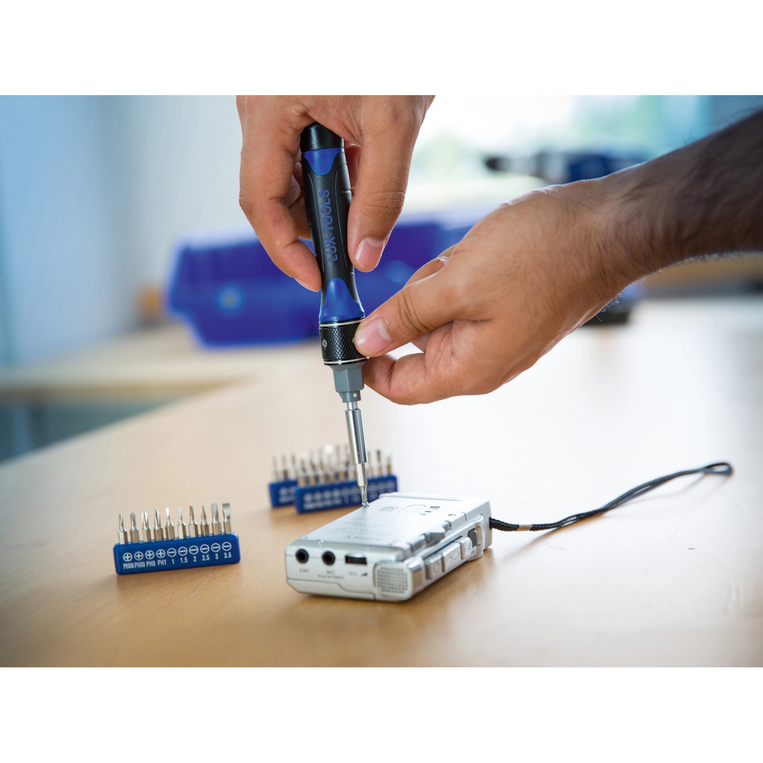 LUX Schraubendreher-Set, 31-teilig, im Einsatz beim Reparieren eines Geräts, Bits in Halterungen.