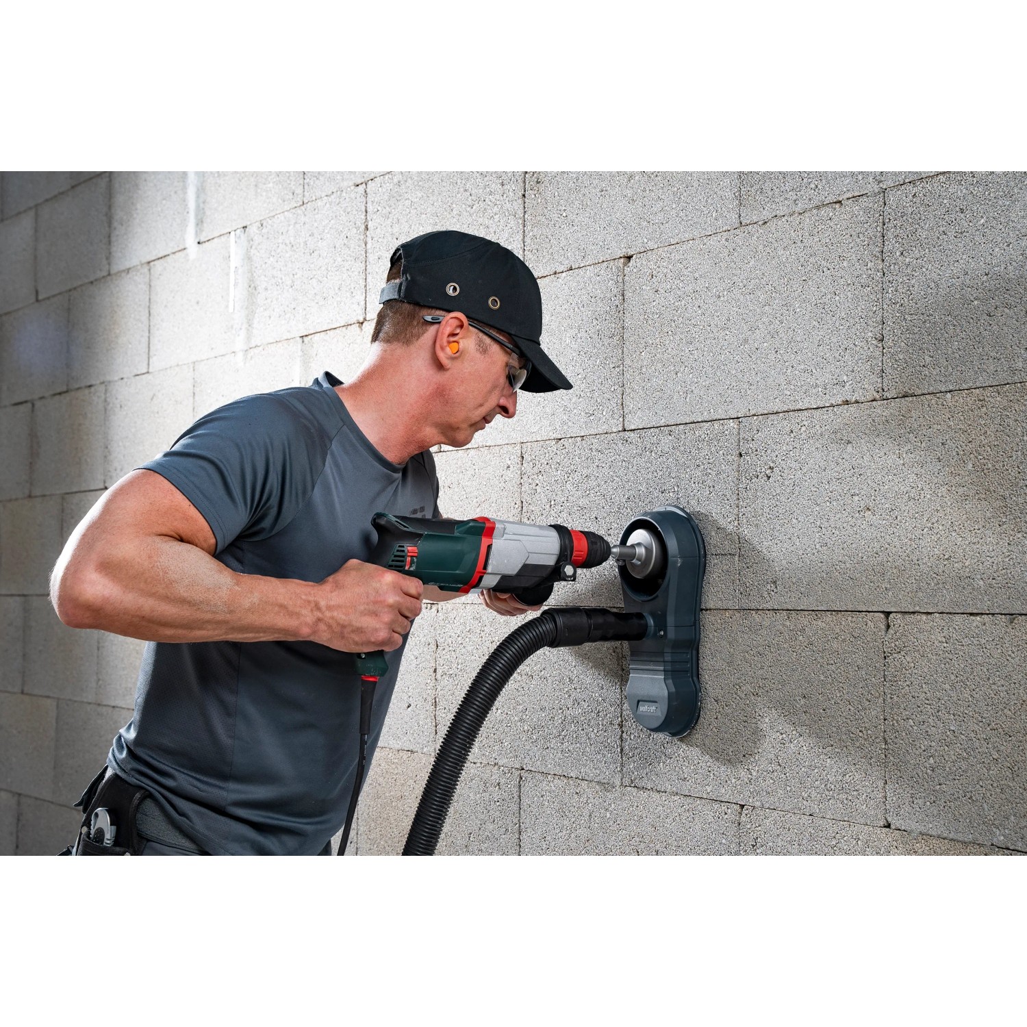 Wolfcraft Absaugsystem HSD 68/100 im Einsatz mit Bohrmaschine an einer Wand.