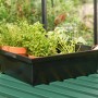 Schwarze Pergart Pflanzwanne aus galvanisiertem Stahl mit Pflanzen und Gartenschaufel.