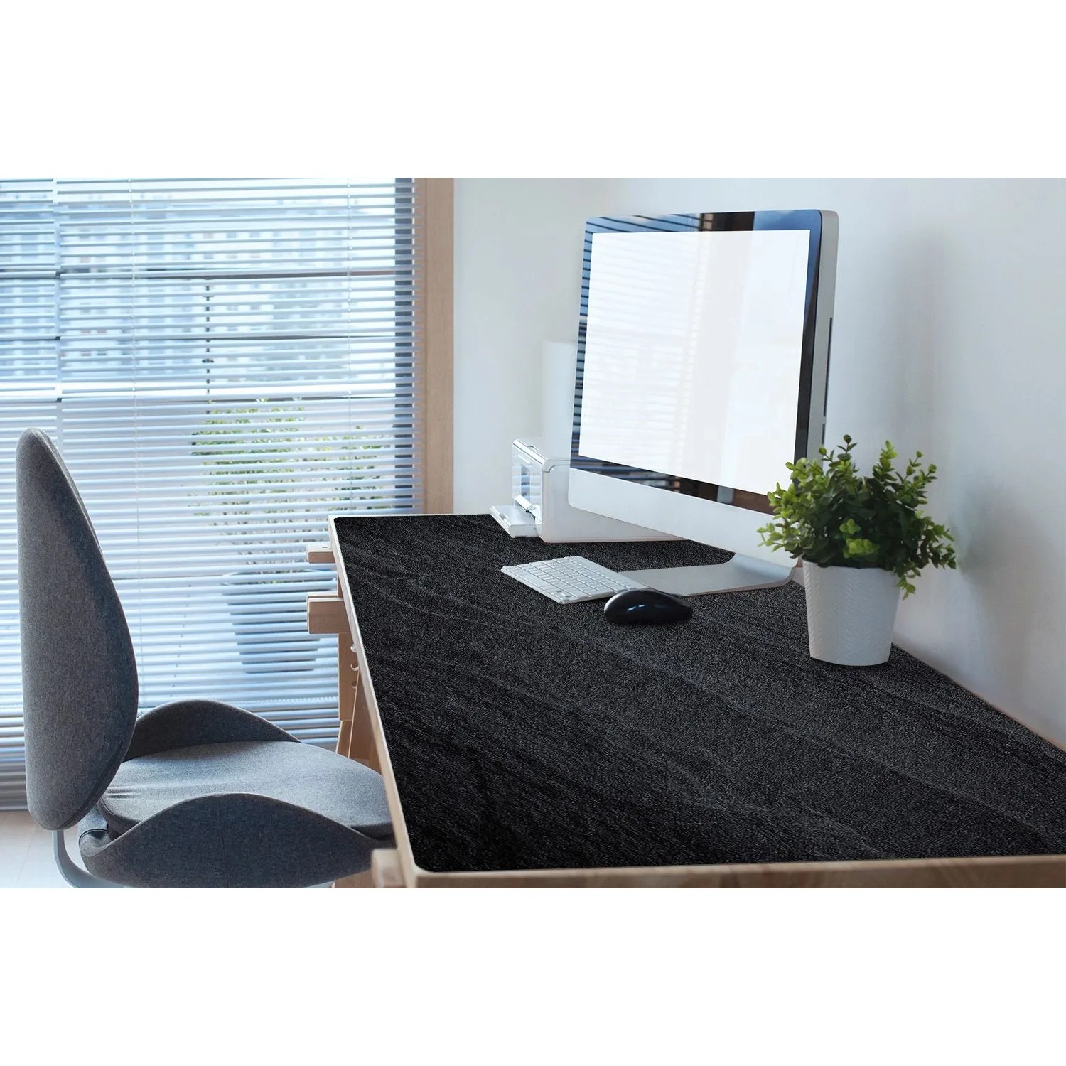 Schwarze Tulup Schreibtischunterlage "Schwarzer Sand" (120x60 cm) auf einem Schreibtisch mit PC.