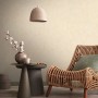 Beige AS-Creation Vliestapete mit grafischer Struktur im Raum mit Lampe und Rattansessel.