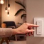 Hand bedient Philips Hue Dimmschalter für smarte Beleuchtung im Wohnraum.