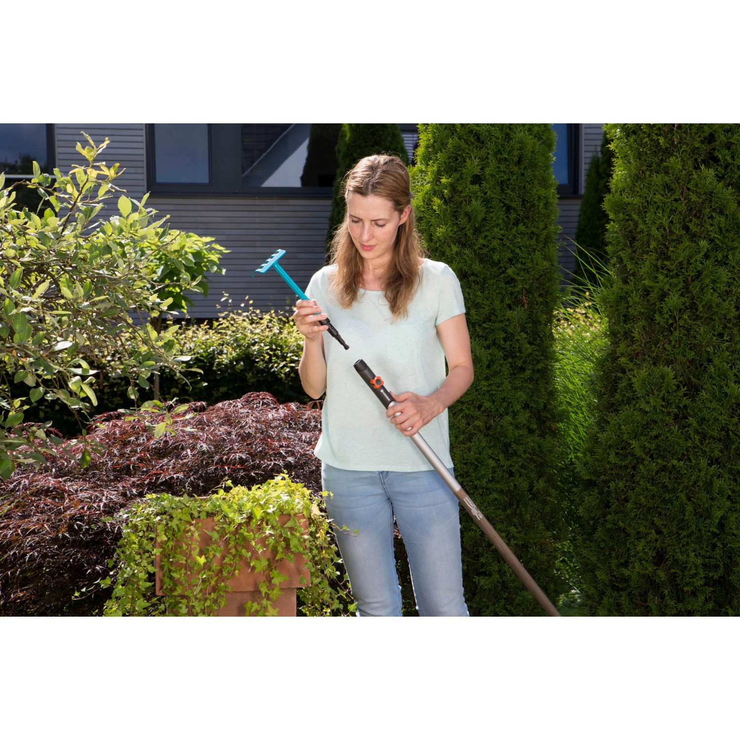 Gardena combisystem Blumenrechen mit Stiel wird von einer Frau im Garten zusammengesteckt.