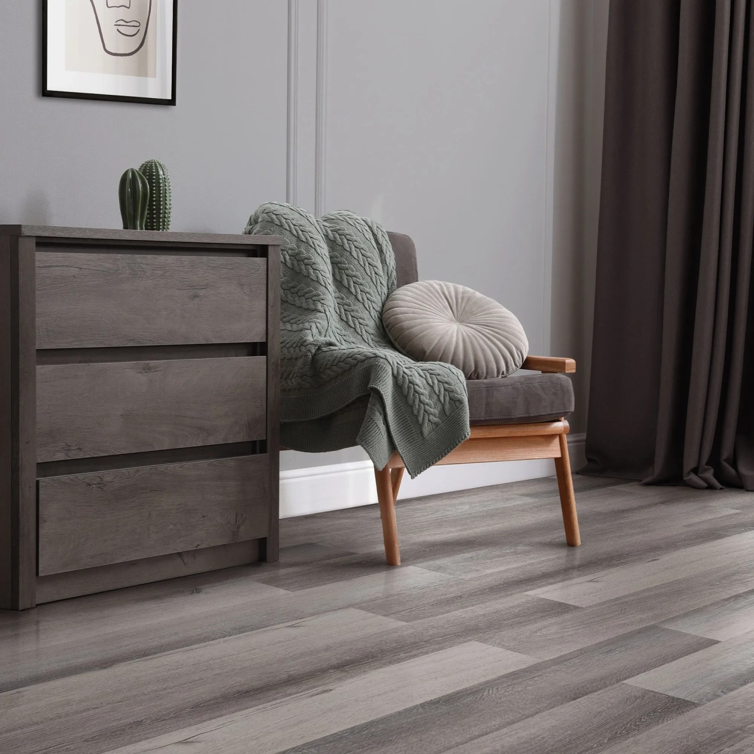 ML-Design Vinylboden Kiefer Grau, selbstklebende Dielen im Wohnraum mit Kommode und Sessel.