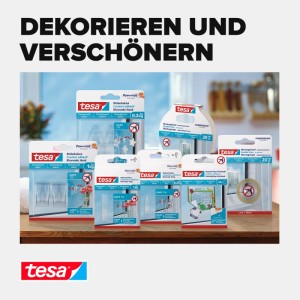 Auswahl an Tesa Powerstrips Klebehaken und Klebebändern für Dekoration, transparent, auf Holztisch. Für sichere Befestigung.