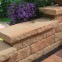 Sandsteinfarbene Bruchsteinmauer Abdeckplatte (60x35x8 cm) auf einer Mauer.