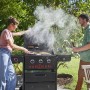 Frau grillt mit Char-Broil Gas2Coal Hybridgrill, Mann mit Bier daneben. Gasgrill mit 3 Brennern im Garten.
