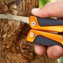 OBI Multitool 12-in-1 Zange mit Sägeblatt in Aktion, orangefarbener Griff.