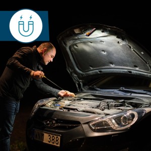 Mann prüft Ölstand im Auto mit Rapid LED-Arbeitsleuchte. Magnetische Baustrahler für Kfz-Reparaturen.
