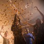 Goldener Konfetti-Regen fällt auf lachende Menschen bei einer Party. Perfekt für Party Popper, Geburtstag, Silvester.