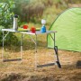 LUX Multifunktionstisch Comfort im Outdoor-Einsatz mit Geschirr und Lampe vor einem Zelt.