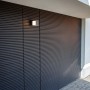 Moderne Lutec LED-Außenwandleuchte Cuba in Anthrazit an einer Fassade. Einstellbare Weißtöne.