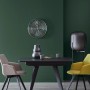 Wohnraum mit Schöner Wohnen Trendfarbe Jungle an der Wand, Esstisch und Stühlen.