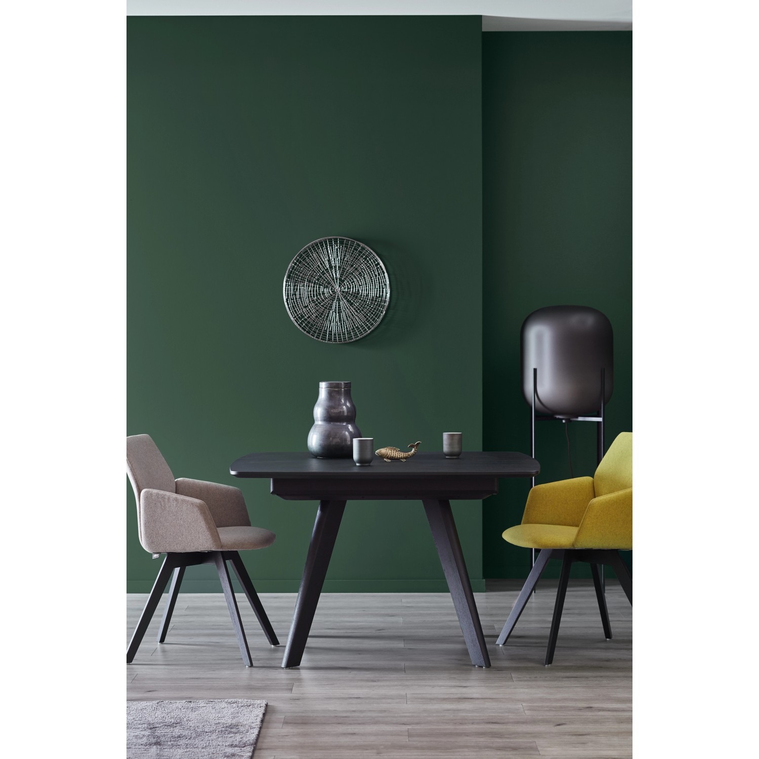 Wohnraum mit Schöner Wohnen Trendfarbe Jungle an der Wand, Esstisch und Stühlen.