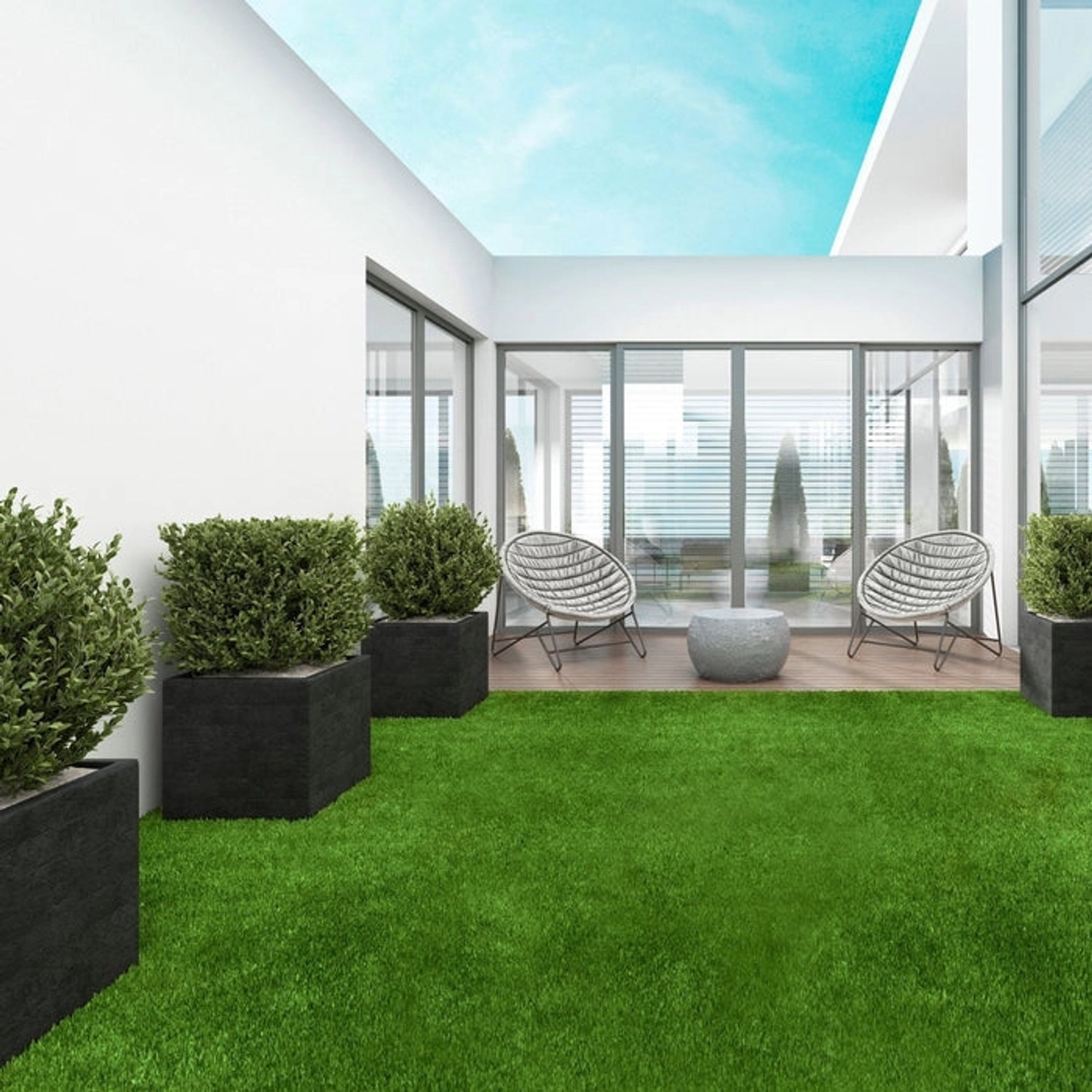 Sonnige Terrasse mit Karat Kunstrasen Lemon, 50mm hoch, mit Sitzgelegenheit und Pflanzen.