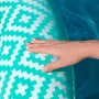 Bestway Pool-Hängematte Comfort Plush, türkis-weiß gemustert, Hand liegt auf der Oberfläche.