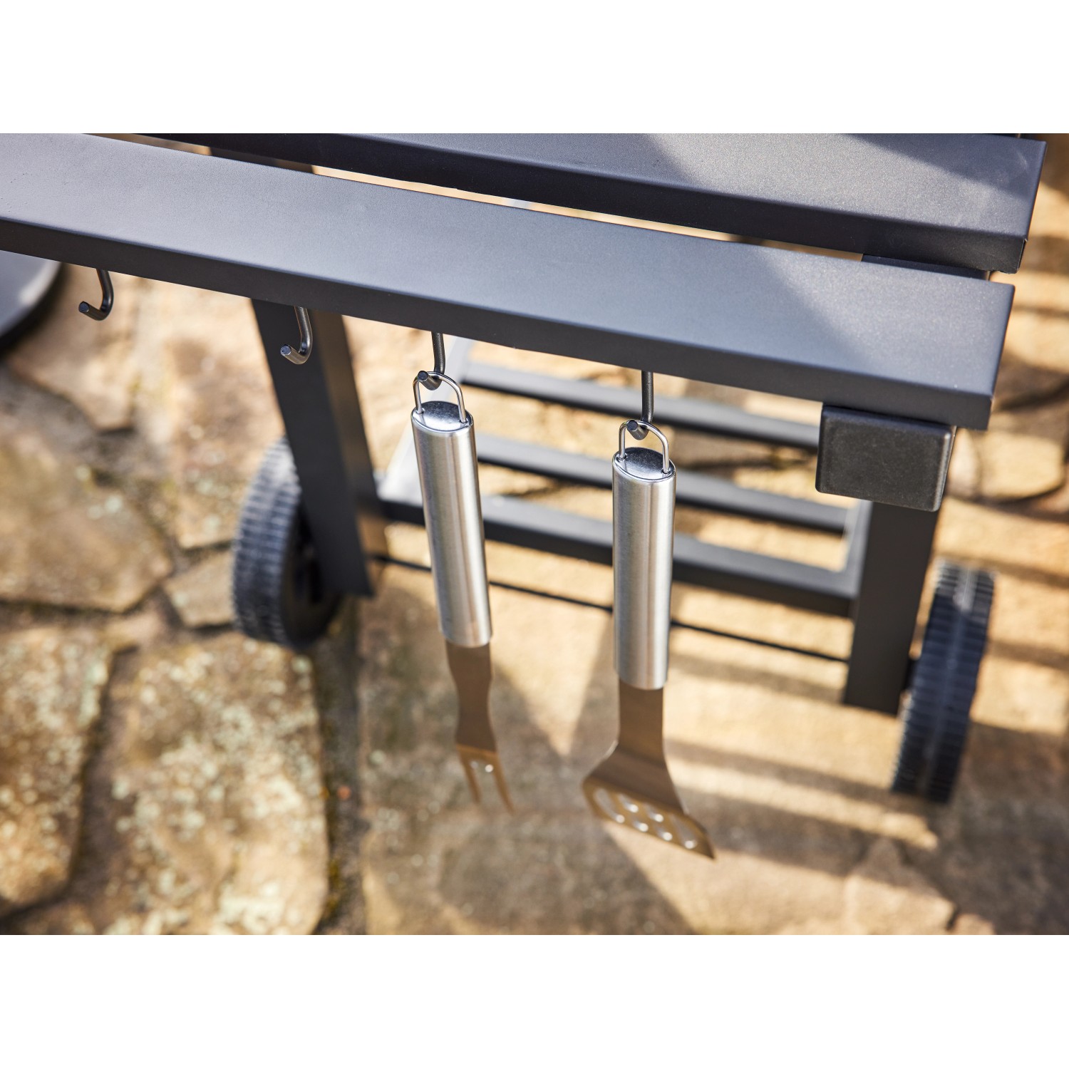 Detailaufnahme: Jamestown Holzkohlegrillwagen Jaxon mit Grillbesteck an Haken.