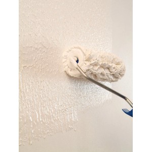 Auftragen von Knauf Easy Putz Fein (1mm) mit einer Farbwalze auf eine Wand.