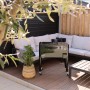 Schwarzer Axi Kühlwagen Retro 76 l auf einer Terrasse mit Sitzgruppe im Hintergrund.