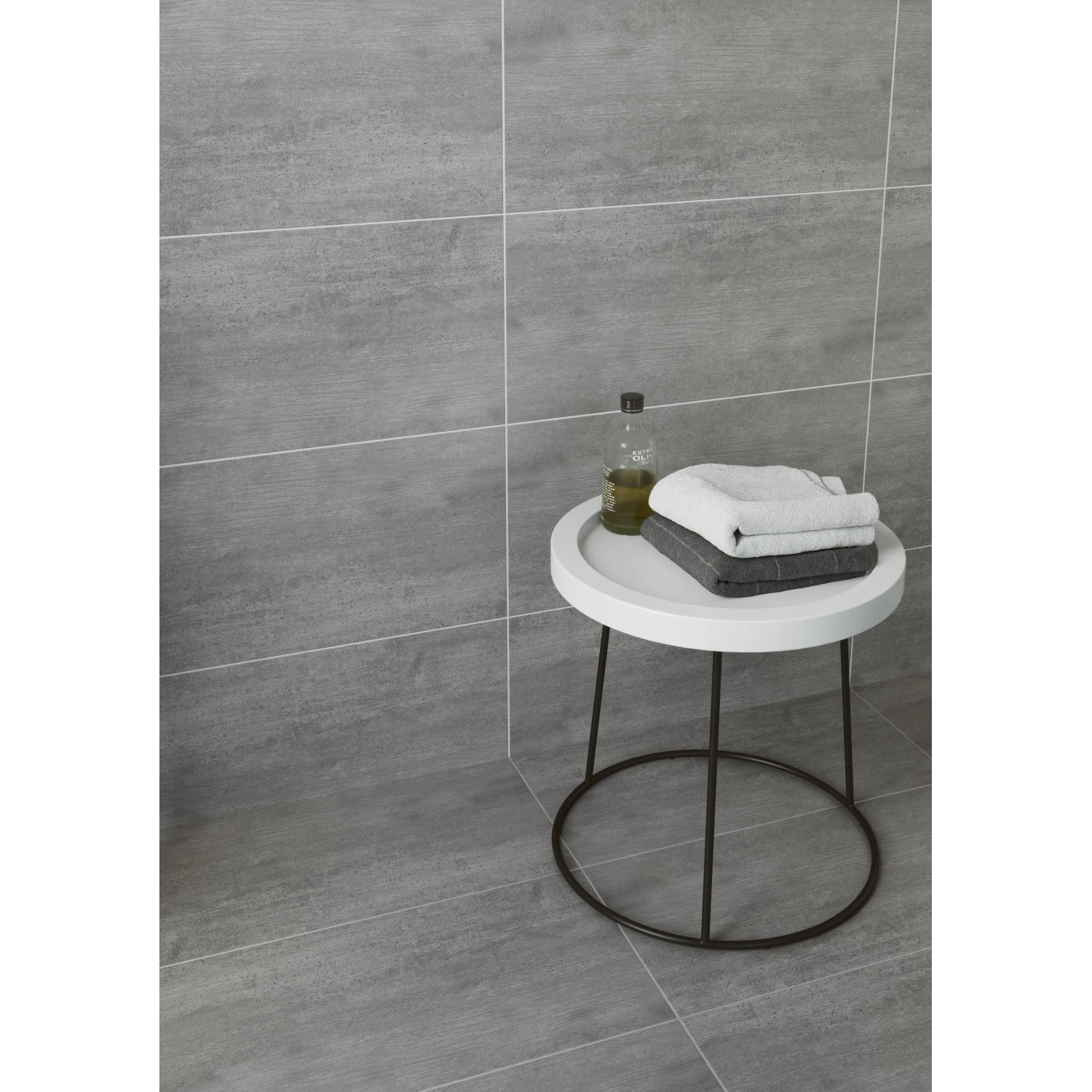 Graue Bodenfliese Harmony Feinsteinzeug, glasiert, 29,7x59,8 cm, Zement-Holzoptik, mit Tisch und Deko.