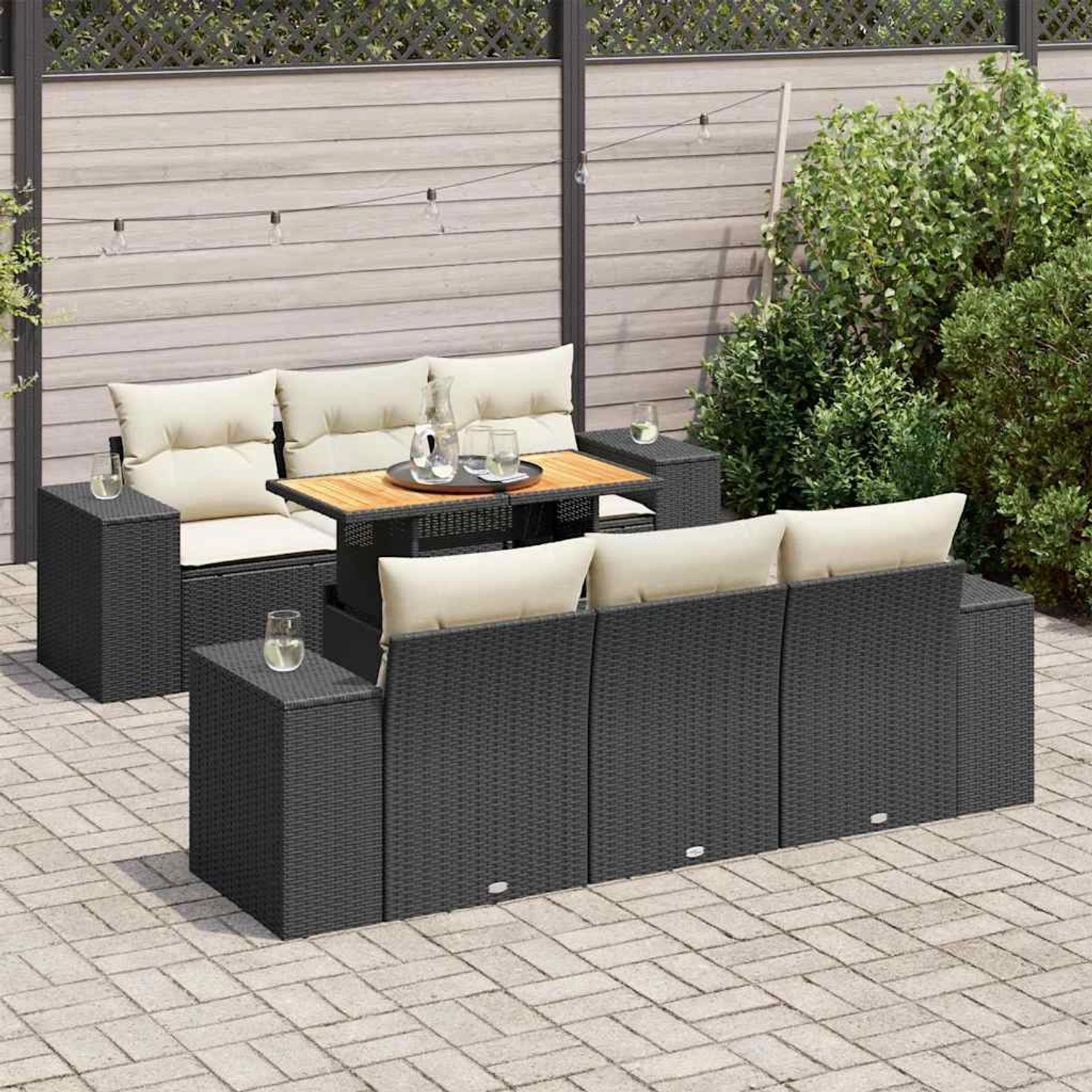 Schwarze 7-tlg. Garten-Sofagarnitur aus Rattan mit Tisch und cremefarbenen Kissen.