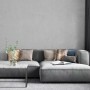 Wohnzimmer mit grauer Marburg Vliestapete Botanica 2 Uni und passendem Sofa.