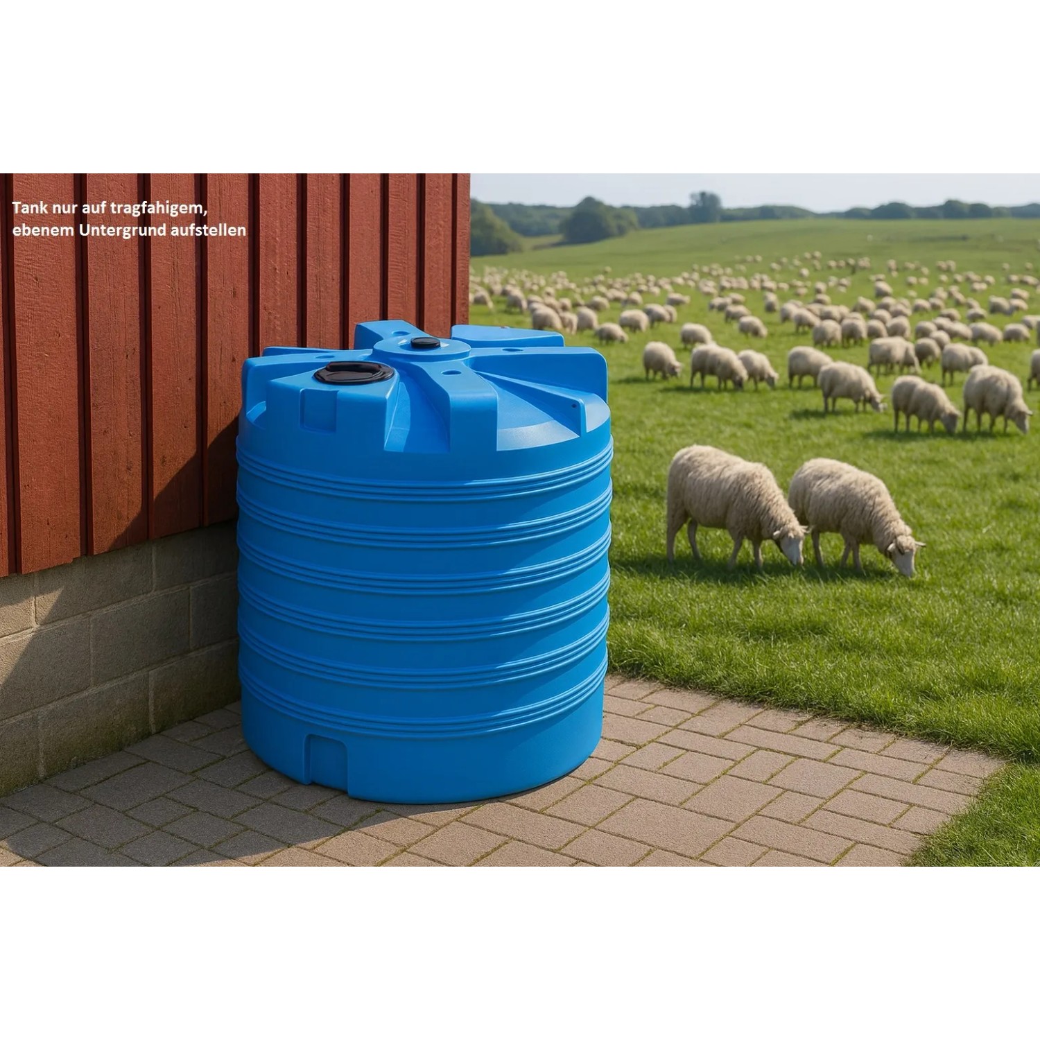 Großer blauer KMND 8000L Trinkwasser Wassertank aus PE mit Rippen, auf Pflaster neben rotem Gebäude, Schafweide.