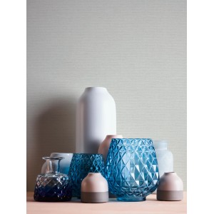 Graue Vliestapete Trendwall 2 Uni mit verschiedenen Vasen im Vordergrund.