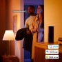 Szene mit Philips Hue Einbauspots: Paar nutzt Sprachsteuerung für smarte Beleuchtung.