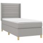 Helles Boxspringbett 90x190 cm mit Matratze und Kopfteil, Stoffbezug.