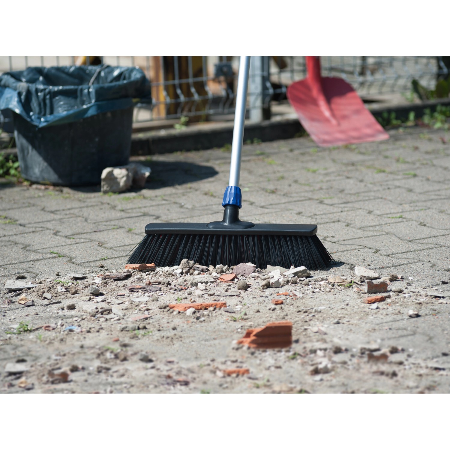 LUX Straßenbesen Professional 2in1 mit Stiel beim Kehren von Schmutz.