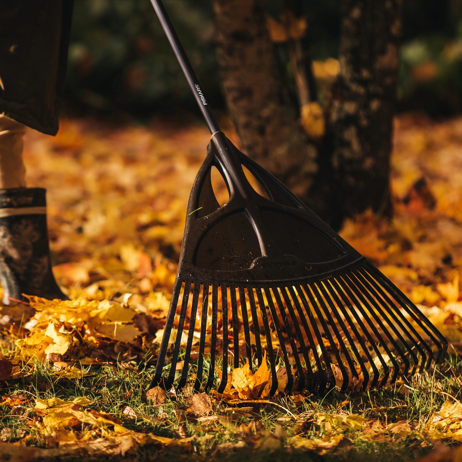 Fiskars Laubbesen Solid XL beim Zusammenkehren von Laub im Garten.