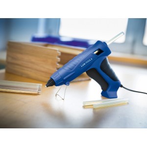 Blaue LUX Heißklebepistole HKP-100/12 Comfort mit Klebesticks und Werkstück.